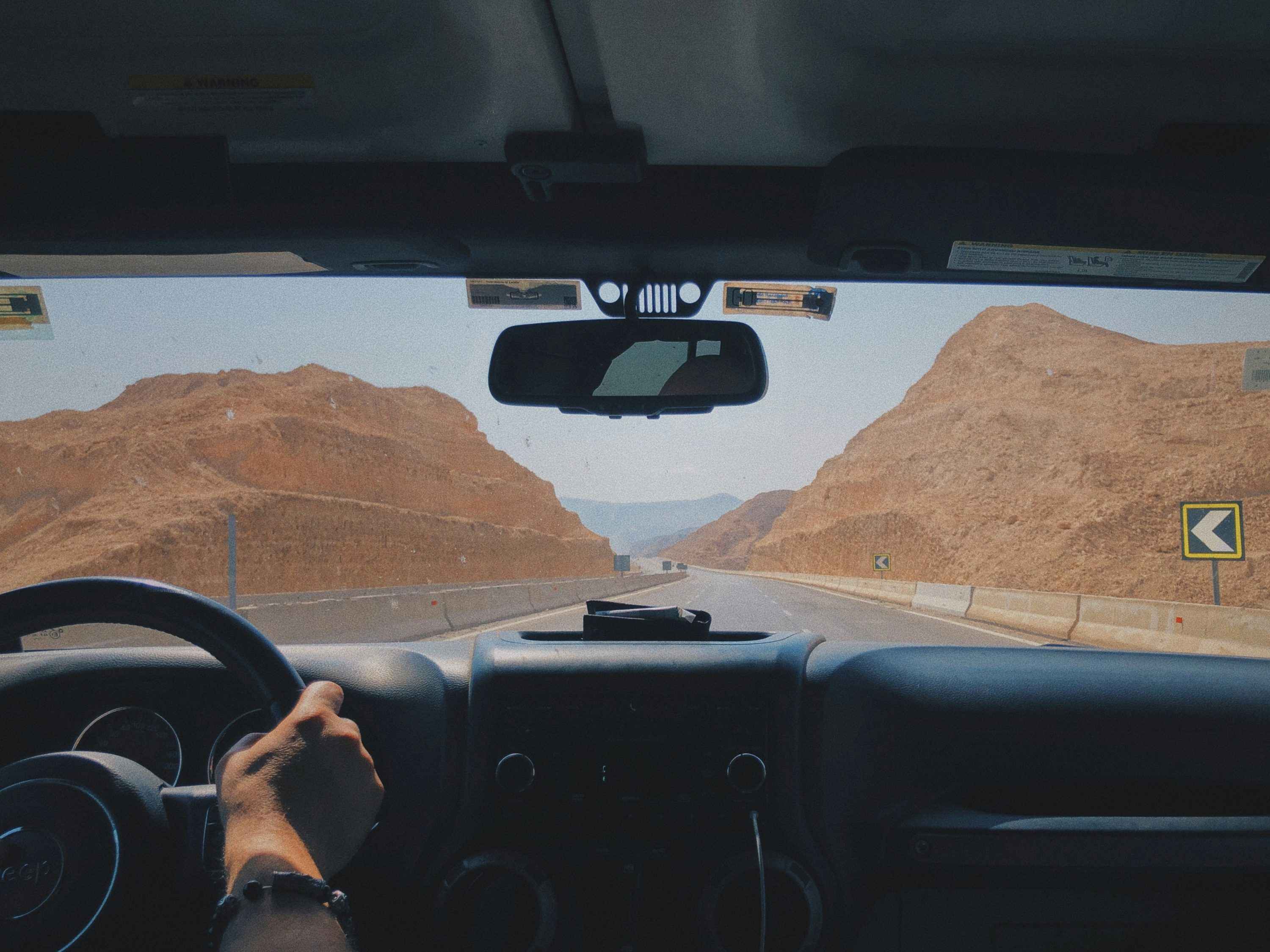 Person driving car on desert road